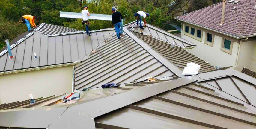 four roofers installing a metal roof